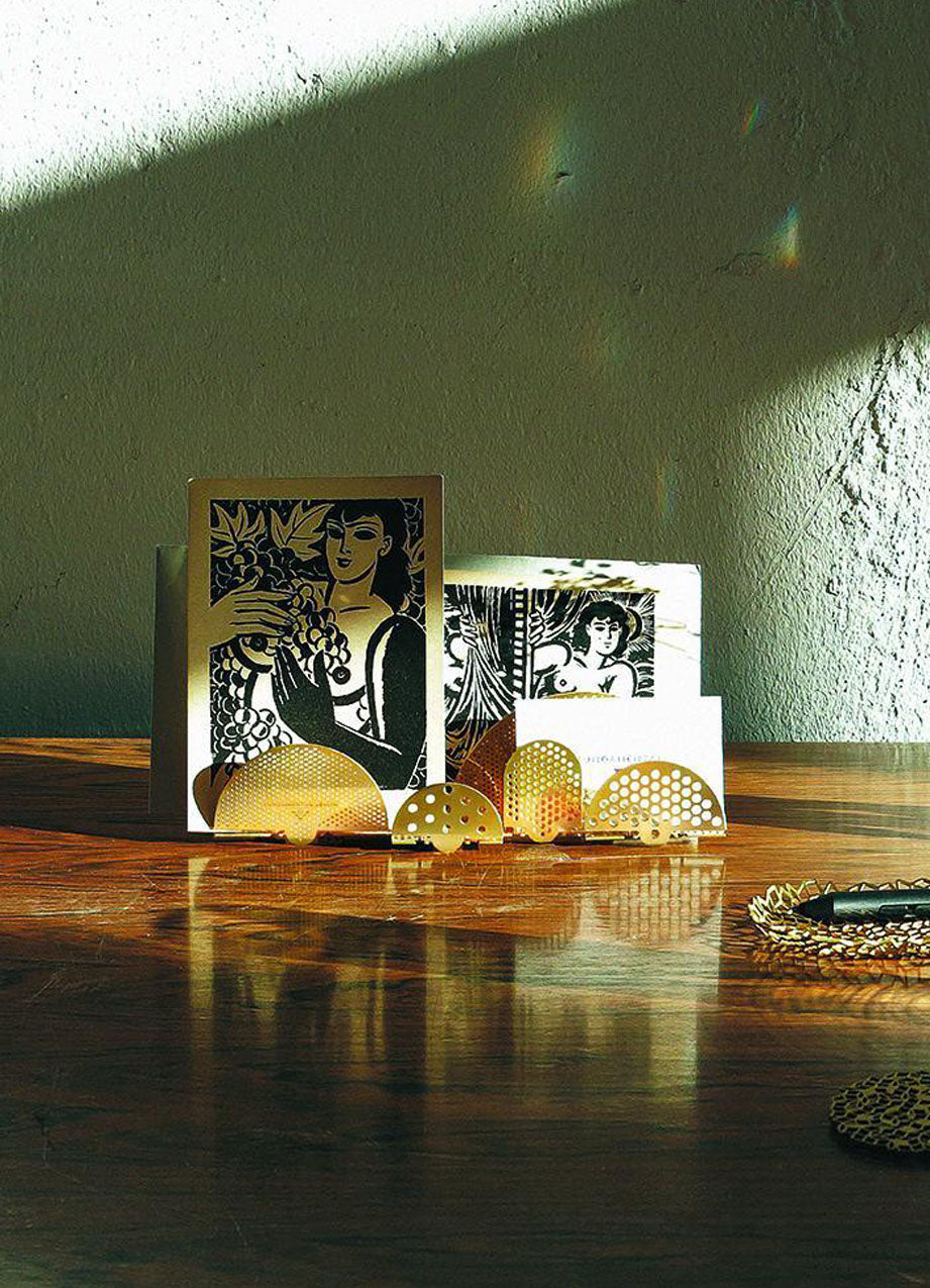 Cloud Desk Tidy on a desk with framed pictures against a green wall